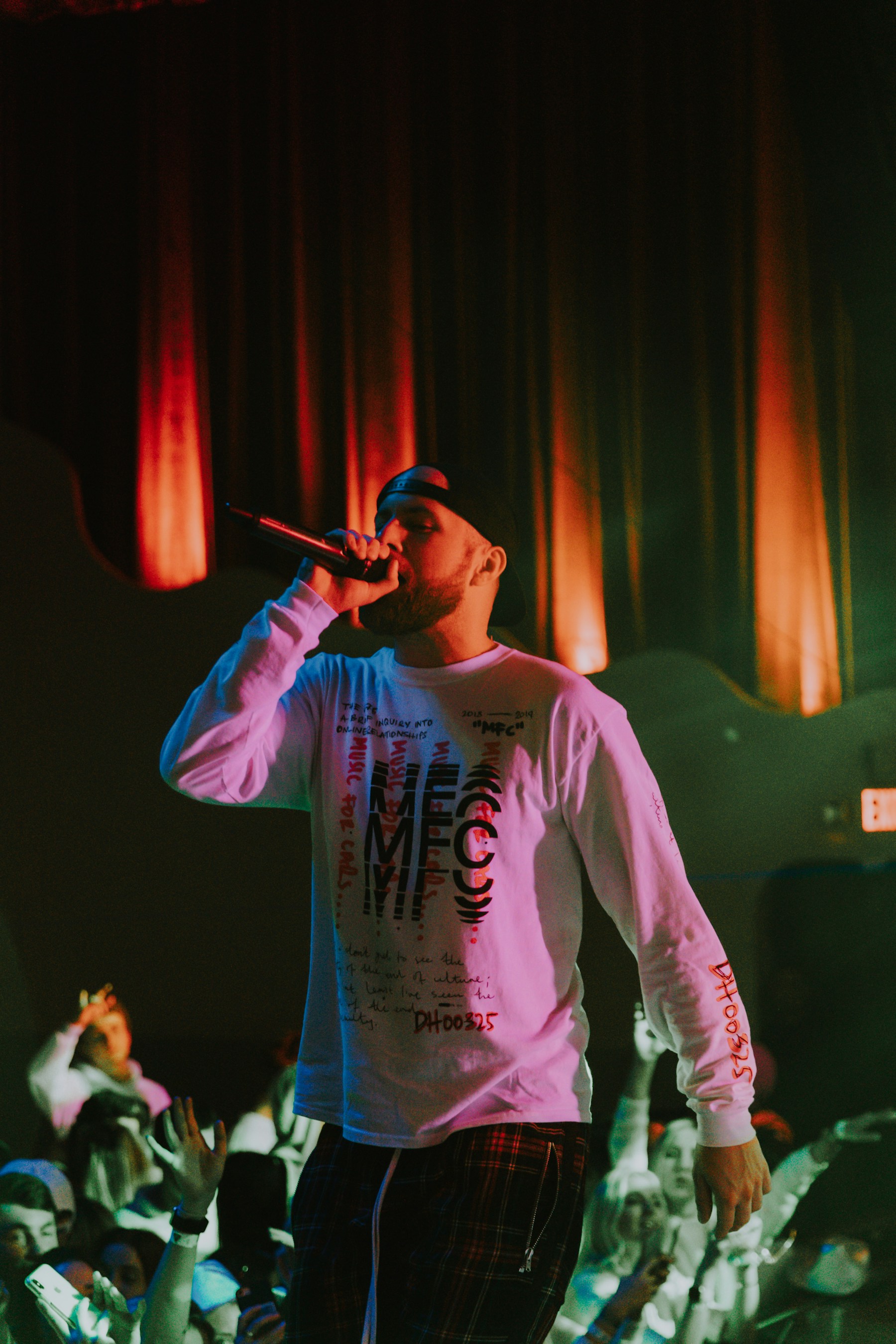 A rapper performing to an outstretched crowd